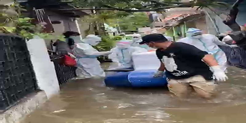 Di Tengah Banjir, Tim Pemulasaran Evakuasi Jenazah Covid-19