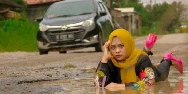 Protes Jalan Rusak dan Berlumpur Tak Juga Diperbaiki, Pasutri Nekat Bermain Lumpur di Kubangan