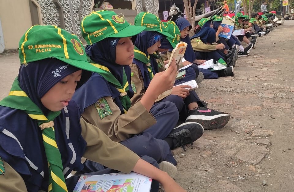 Peringati Milad, SD Muhammadiyah Pacul Gelar Aksi Membaca Sepanjang Jalan 